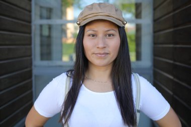 Pantolon askısı ve klasik şapka takan bir kadın. 