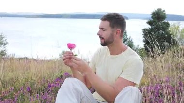 Pembe gülle tarlada oturan adam, yaklaş.