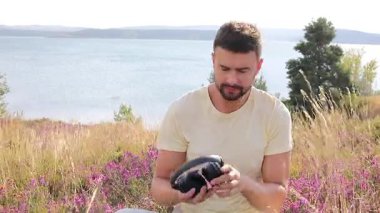 Kulaklıklarıyla müzik dinleyen yakışıklı bir adam. 