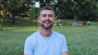 Genç adam parktaki kamerada iyi işareti gösteriyor..