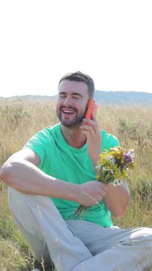 Akıllı telefonlu buğday tarlasında yakışıklı bir adam.