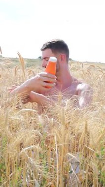 Sahada güneş kremi süren mutlu yakışıklı adam.