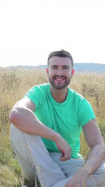 Adam sahada, gülümsüyor ve kameraya bakıyor..