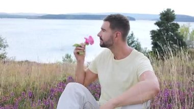 Pembe gülle tarlada oturan adam, yaklaş.