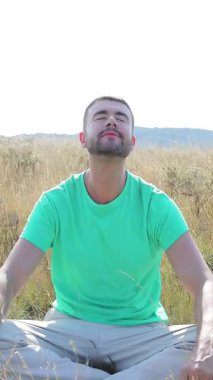 Yakışıklı adam doğada meditasyon yapıyor, yakın çekim.