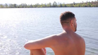 Yazın gölün arka planındaki yakışıklı genç adam.