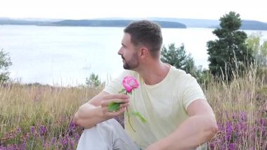 Pembe gülle tarlada oturan adam, yaklaş.