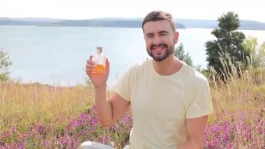 Doğal ortamında parfüm kullanan bir adam. 