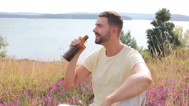 Göl kenarında bira içen genç adam, yaklaş.