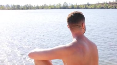 Yazın gölün arka planındaki yakışıklı genç adam.