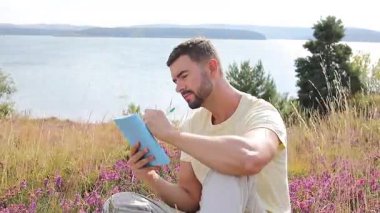 Göl kenarındaki defterde yazan yakışıklı adam.