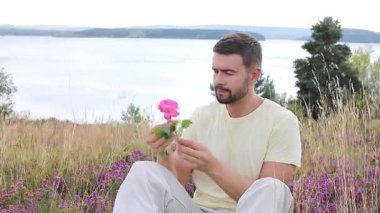 Pembe gülle tarlada oturan adam, yaklaş.