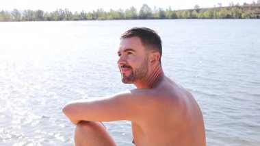 Genç adam yazın gölün arka planında