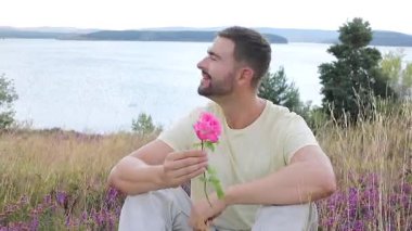 Pembe gülle tarlada oturan adam, yaklaş.