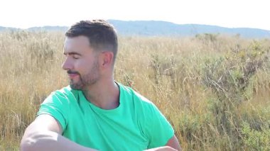 Dağdaki tişörtlü genç adam.