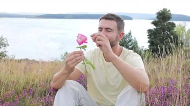 Pembe gülle tarlada oturan adam, yaklaş.