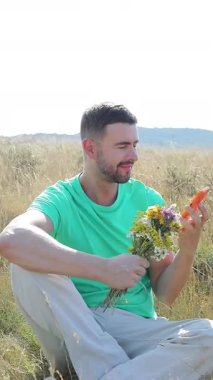 Doğanın arka planında çiçek demeti olan bir adam.