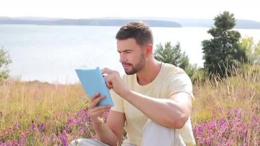 Yakışıklı, mutlu, doğasında not defteri olan bir adam.