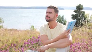 Yakışıklı, mutlu, doğasında not defteri olan bir adam.