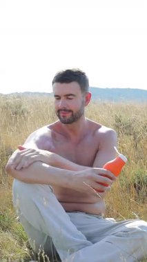 Yazın koruyucu güneş kremi kullanan bir adamın dikey videosu. 