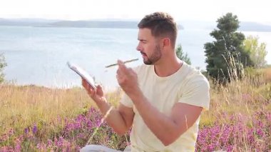 Buğday tarlasında defteri olan mutlu adam, yaz günü.