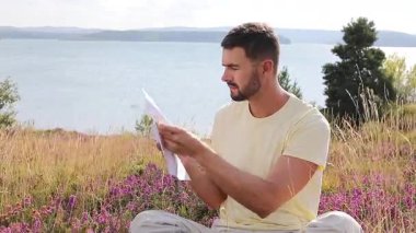 Buğday tarlasında defteri olan mutlu adam, yaz günü.