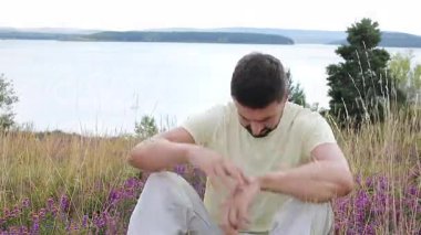 Çimlerde oturan ve göl kenarındaki çiçeklerde.