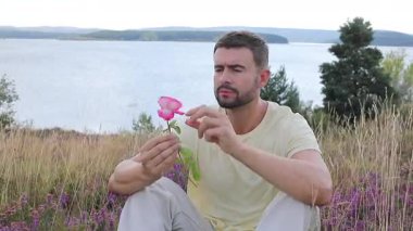 Pembe gülle tarlada oturan adam, yaklaş.