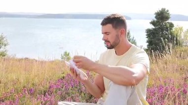 Buğday tarlasında defteri olan mutlu adam, yaz günü.