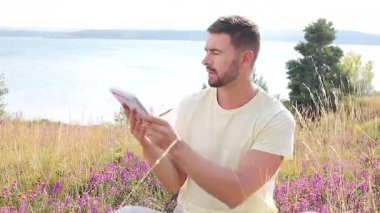 Buğday tarlasında defteri olan mutlu adam, yaz günü.