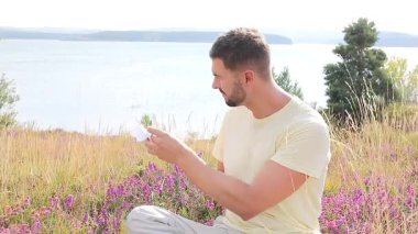 Buğday tarlasında defteri olan mutlu adam, yaz günü.