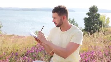 Buğday tarlasında defteri olan mutlu adam, yaz günü.