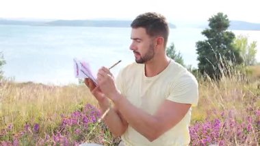 Buğday tarlasında defteri olan mutlu adam, yaz günü.