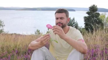 Pembe gülle tarlada oturan adam, yaklaş.