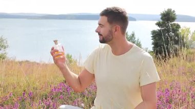 Doğal ortamında parfüm kullanan bir adam. 