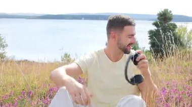Yakışıklı adam doğada müzikle rahatlıyor.