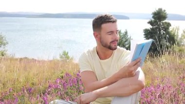 Buğday tarlasında defteri olan mutlu adam, yaz günü.