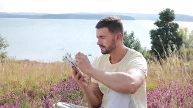 Buğday tarlasında defteri olan mutlu adam, yaz günü.