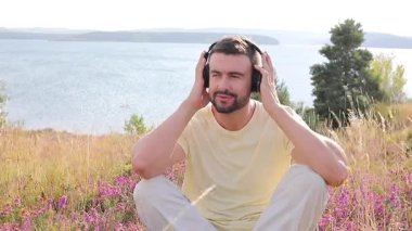Yakışıklı adam doğada müzikle rahatlıyor.