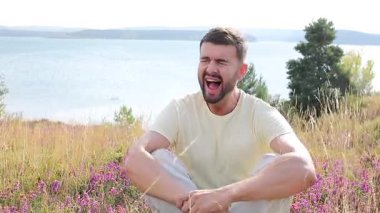 Suyun Doğal Ayarlarında Otururken Açık havada Bağıran Genç Adam.