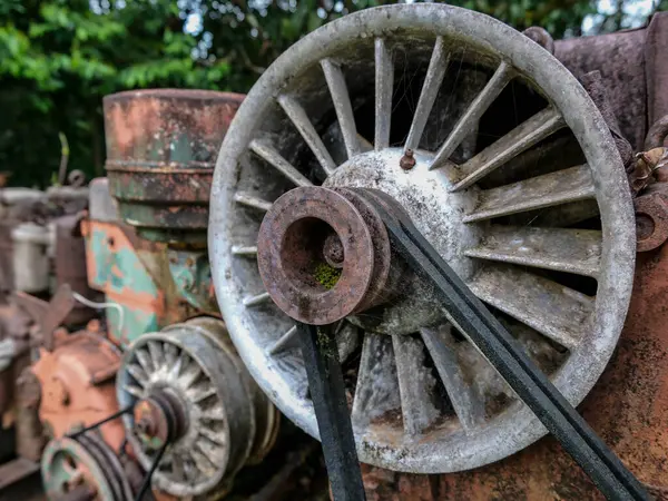 Büyük tekerlek ve cıvatalı paslı bozuk makineler.