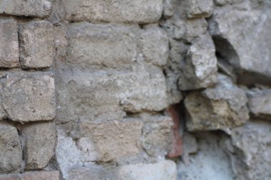 Parçalanmış tuğla duvar, uzun zamandır terk edilmiş bir yeri işaret eden tuğla ve alçı tabakalarıyla zamanın ve havanın etkilerini sergiliyor..