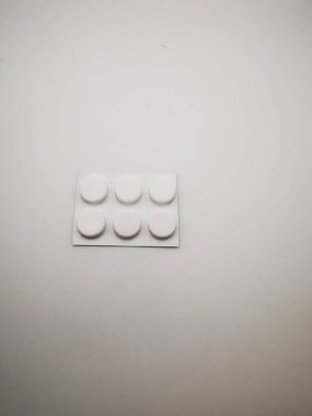 A blister pack holds six round white tablets on a clean white surface. The packaging is simple, emphasizing the tablets, often used for medication or supplements. clipart