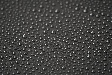 Siyah arkaplanda su damlaları var.