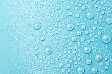 Su damlaları mavi arka planda, yakın planda.