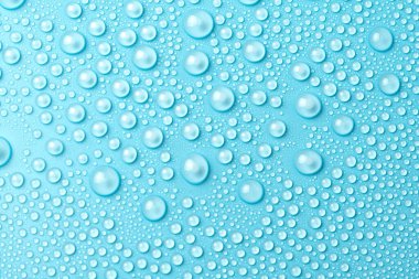 Su damlaları mavi arka planda, yakın planda.