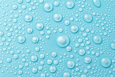 Su damlaları mavi arka planda, yakın planda.