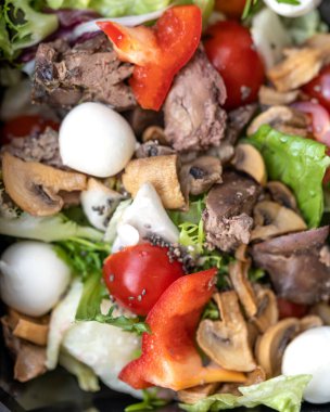 Çiğ sebze salatası, renkli karnabahar, marul, dolma biber, mozzarella, domates ve kızarmış tavuk ciğeri. seçici odak