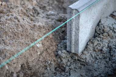 Bir yol inşaatında beton kaldırım kurulumu ve kurulumuna yakın çekim