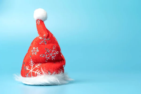 stock image Decorative santa's hat on a blue background with a New Year's ornament